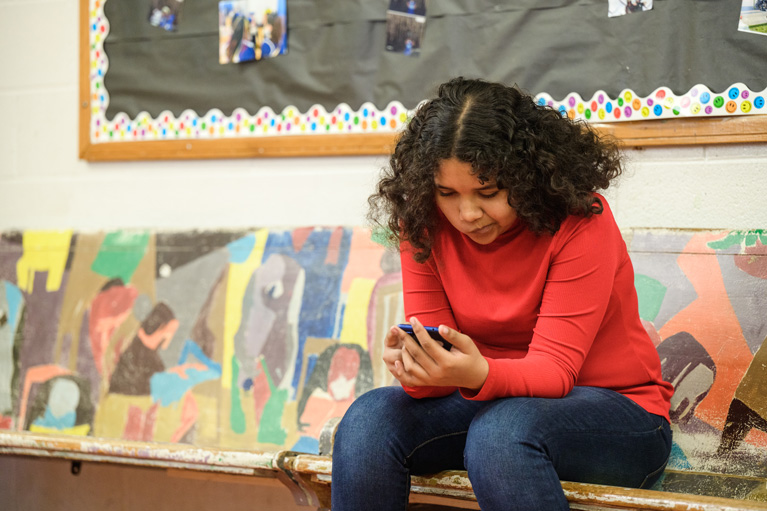 Club kid pensively looking at her phone