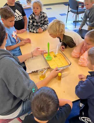 Youth around table with freshly baked cornbread