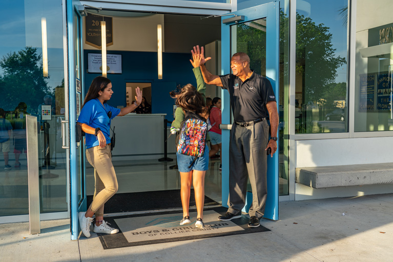 Club kid high-fiving YDPs at front door