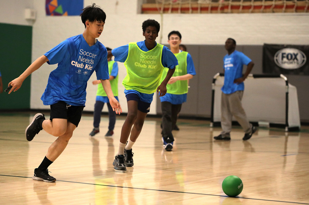 Club kids and teens playing soccer